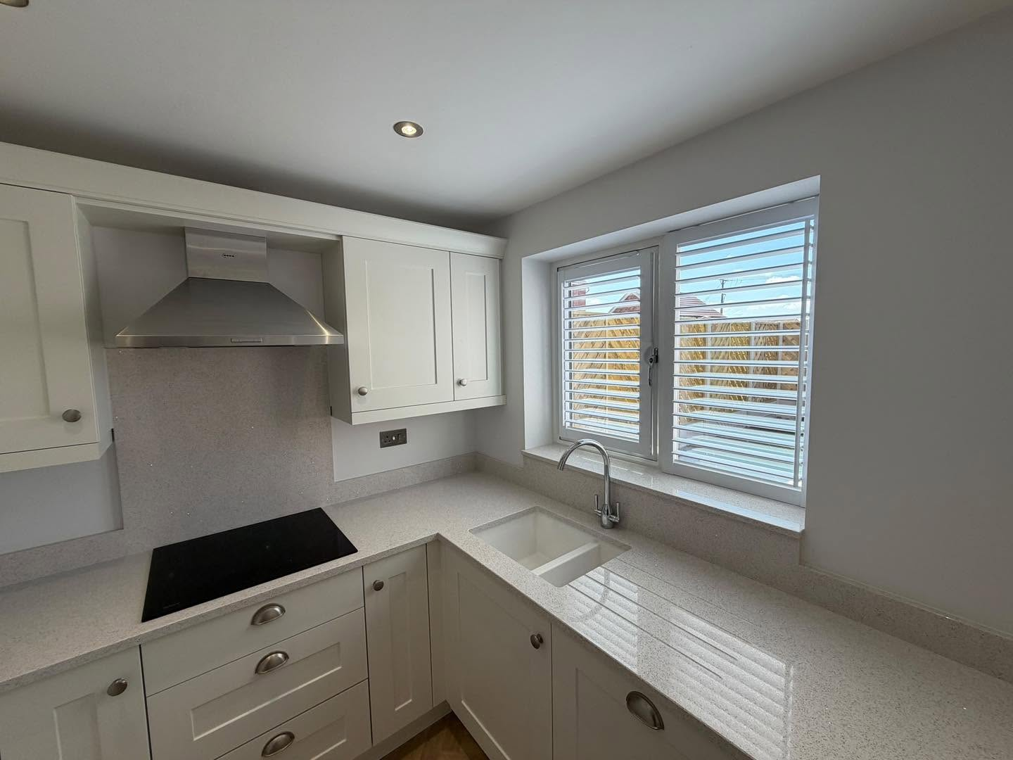 White plantation shutters in a modern kitchen window