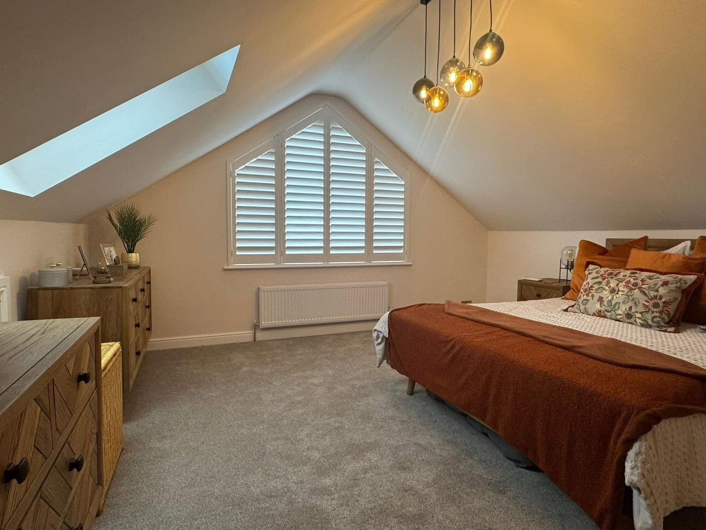 White plantation shutters in a shaped apex bedroom window